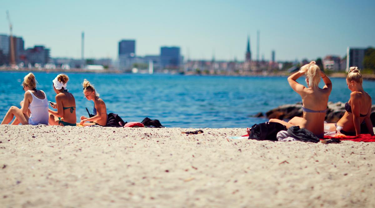 picture of Den Permanente Beach with young ladies sitting on the sand