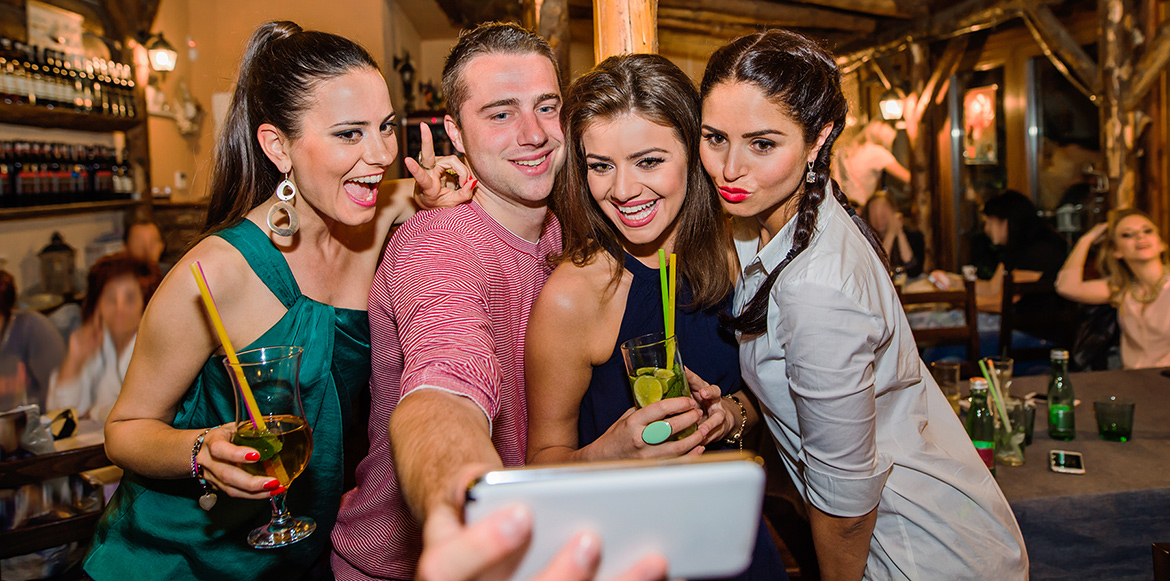 picture of four young ones with drinks having fun