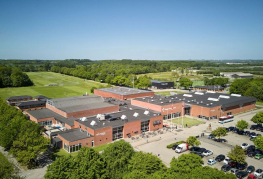 Luftfoto af værelser, hytter og sportsbaner ved Danhostel Vejen Sport Resort.