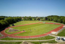 Luftfoto af værelser, hytter og sportsbaner ved Danhostel Vejen Sport Resort.
